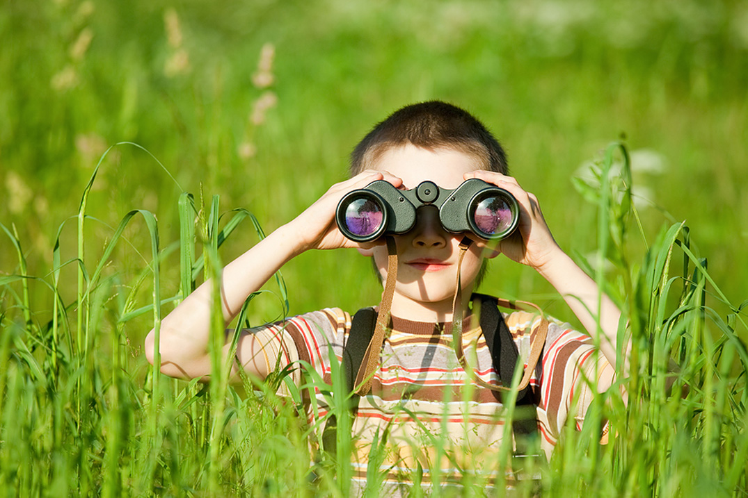 Niño observando con unos binoculares