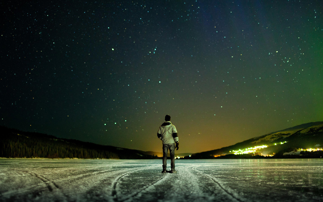Un hombre bajo un cielo estrellado.